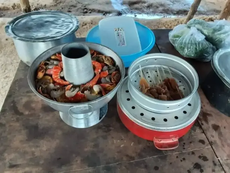 Ein traditioneller Feuertopf mit Gemüse und Fleisch auf dem Tisch.