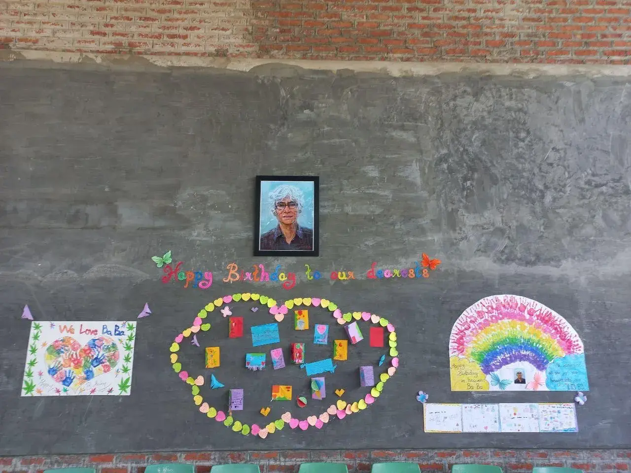 Wand mit Foto von Eric Trutwein, umgeben von Regenbogen und bunten Herzen.
