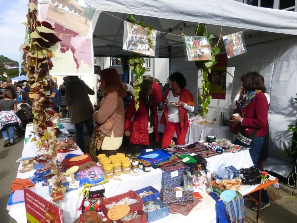 Vereinsstand auf dem Herbstmarkt Staig 2013 mit Tischen voller Handarbeiten und Besucherinnen.