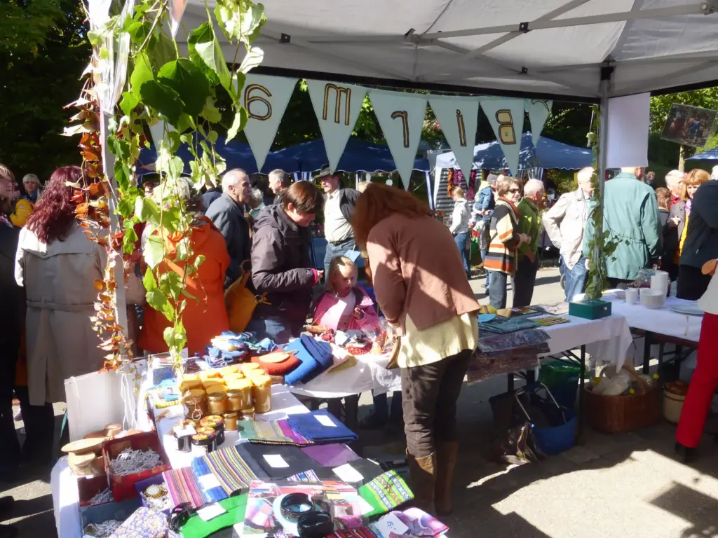 Besucher drängen sich am Herbstmarkt 2013 um den Stand, darüber hängt eine Wimpelkette mit dem Wort Birma.