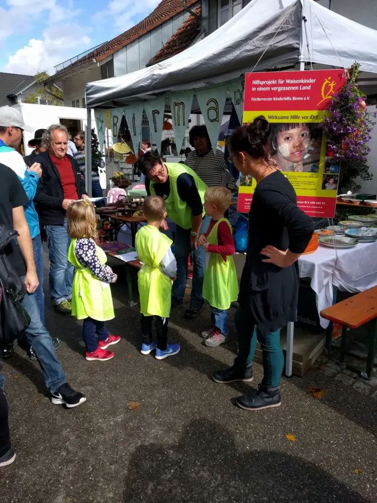 Besucherinnen und Kinder vor dem Vereinsstand auf dem Herbstmarkt 2017.