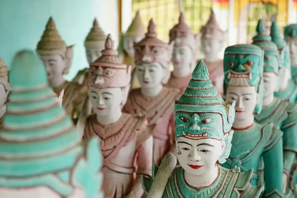 Reihen bemalter Figuren in einem buddhistischen Tempel.