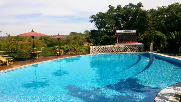 Pool des Lei Thar Gone Guesthouse mit Sonnenschirmen.