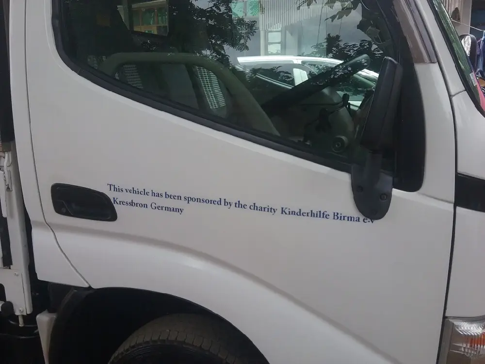 Aufschrift an der Fahrertür, dass der Wagen vom Förderverein Kinderhilfe Birma gespendet wurde.