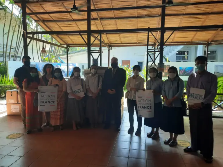 Gruppenfoto aller Beteiligten der Maskenübergabe mit Plakaten.