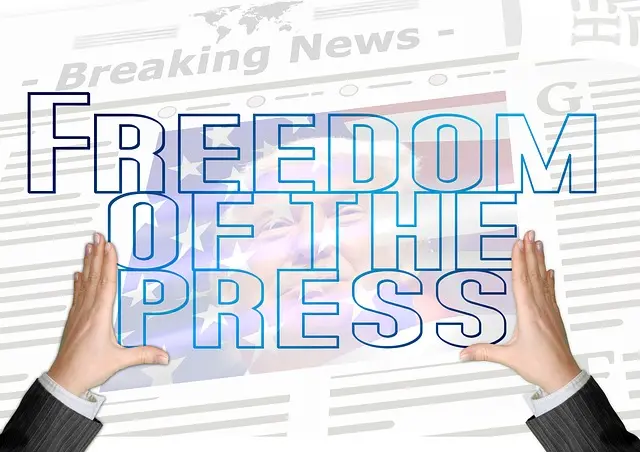Grafik mit dem Schriftzug Freedom of the Press auf einer Zeitungsseite, von zwei Händen gehalten.