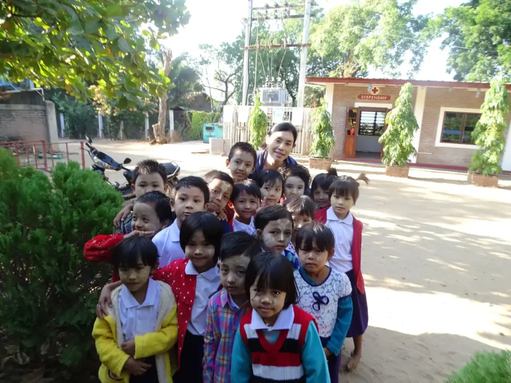 Eine Gruppe kleiner Kinder steht vor dem Eingangsbereich der Schule.